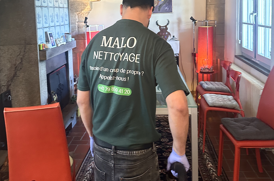 Homme de dos portant un t-shirt Malo Nettoyage passant l’aspirateur chez un particulier